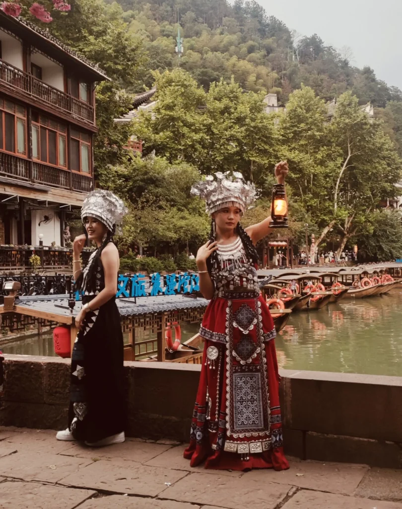 dos chicas posando con traje tradicional de etnias del sur de China